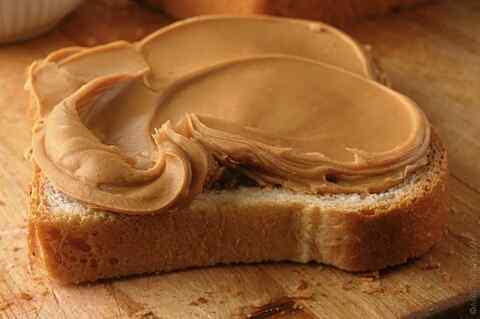 Thick Layer of peanut butter on bread for a peanut butter addict